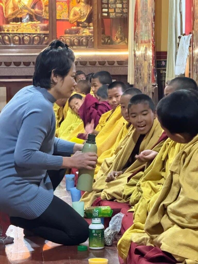 Integrative medicine volunteer attending to monks at Segyu Gaden Phodrang Monastery